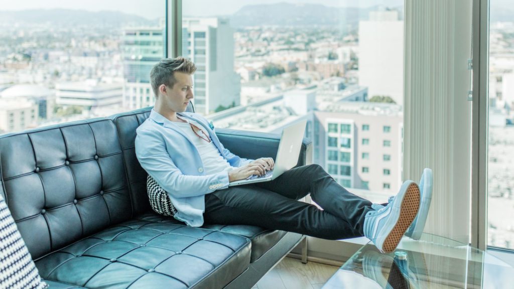 Man on couch doing business analytics.