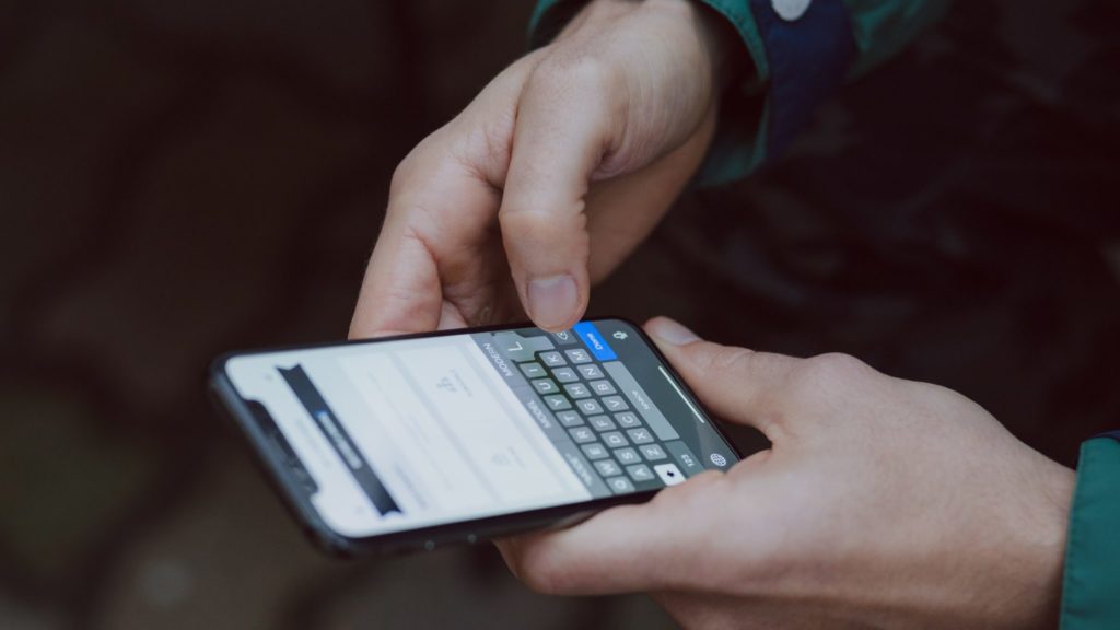 Hands messaging on an iPhone.